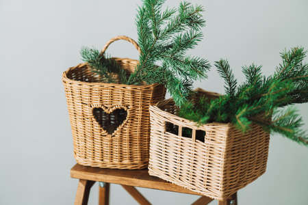 Branches of Christmas tree in wicker baskets on wooden stepladder.の写真素材