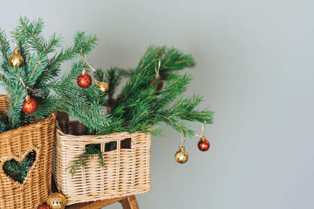 Branches of Christmas tree with bauble in wicker baskets on wooden stepladderの写真素材