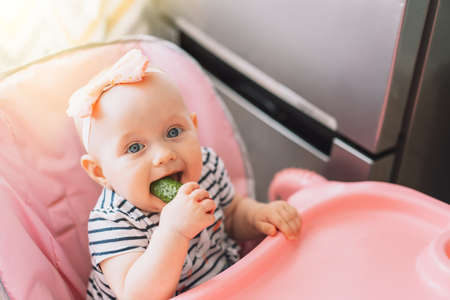 The child eats ripe cucumber.