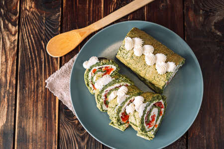 Chopped roll with spinach and red fish on plate