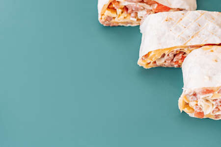 Shawarma cut into three pieces on cyan background.の写真素材