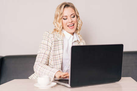 Business lady happily works at the laptop.の写真素材