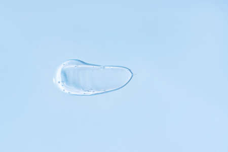 Smeared transparent cream on blue background.の写真素材