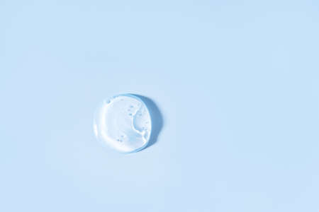 Drop of transparent serum on blue background.の写真素材