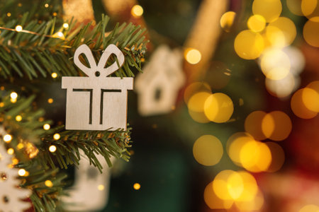 Decorated branch of christmas tree close up with wooden toys and garland.の写真素材