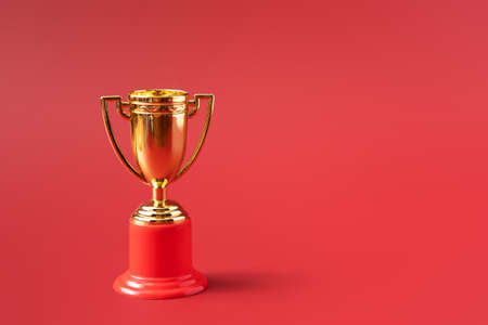 Gold color victory cup on red background.の写真素材