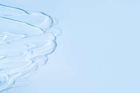 Transparent cream is smeared on blue background.の写真素材