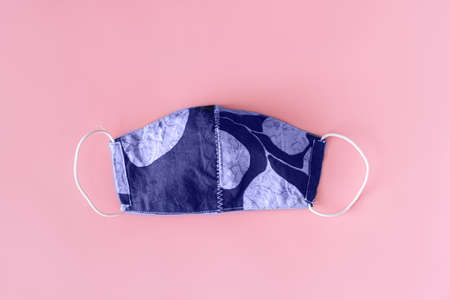 Peri purple protective mask with print on pink background.の写真素材