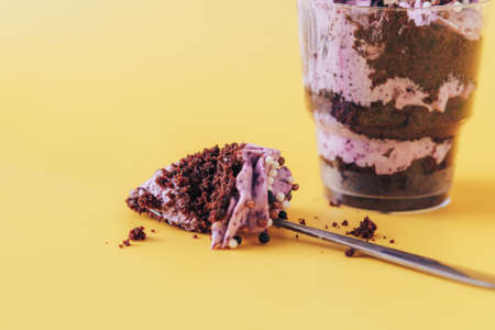 Puff cupcake in glass with spoon on yellow backgroundの写真素材