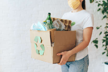 Girl carries box of garbage for recycling