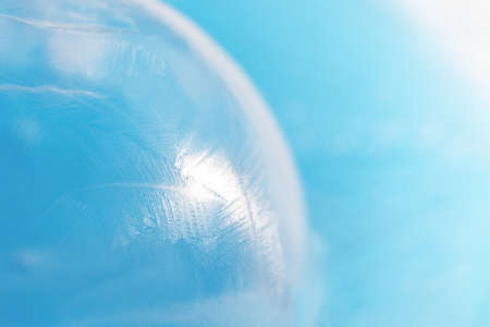 Frozen surface of soap bubble against blue background
