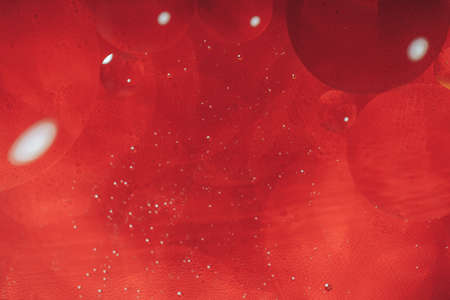 Bubbles close-up in the water against red backgroundの写真素材