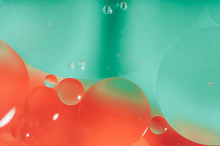 Oil circles on the surface of the water against colored backgroundの写真素材