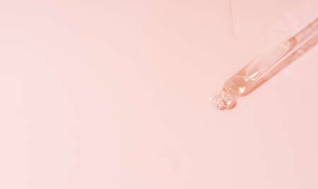 Liquid flows out of pipette on pink backgroundの写真素材