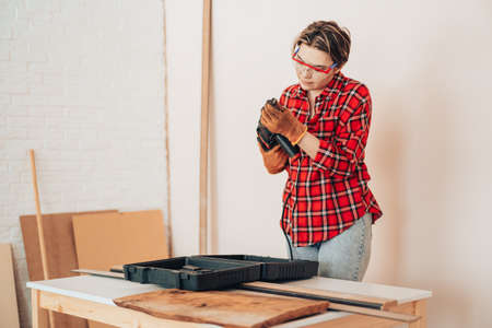 Laborer girl inserts drill into drillの写真素材