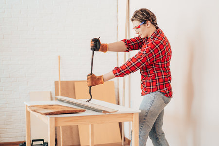 Laborer girl with crowbar in her hands breaks boardsの写真素材