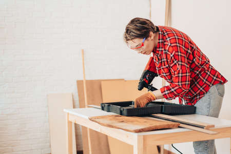 Laborer girl takes out drill for drillの写真素材