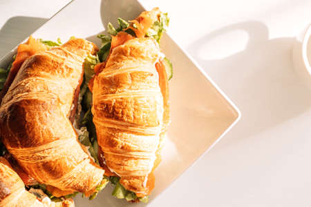 White plate with croissants stands on white tableの写真素材