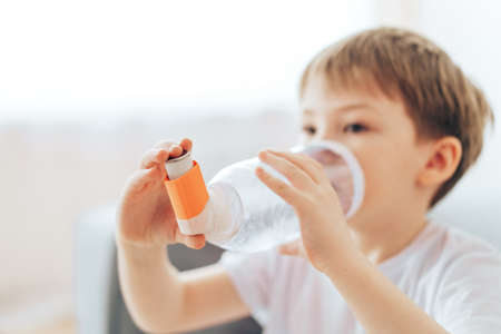 Boy inhales asthma medicine through homemade spacerの写真素材