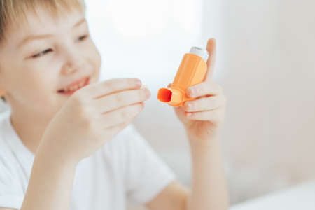 Boy opened the lid and examines the inhalerの写真素材