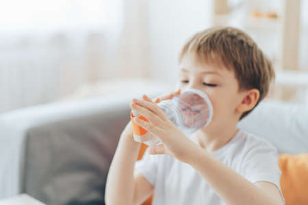 Little boy inhales medicine through homemade spacerの写真素材