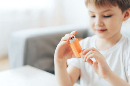 Little boy holding asthma inhaler close upの写真素材