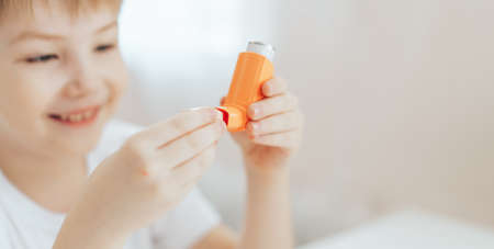 The little boy opened the lid and examines the inhalerの写真素材