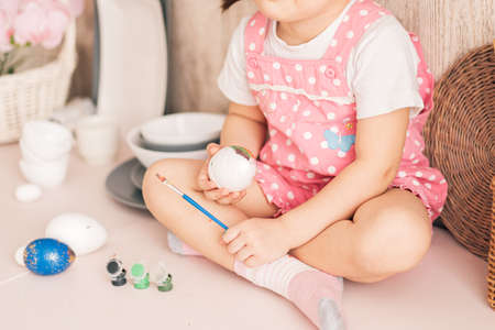 Little Child paints eggs with different colorsの写真素材