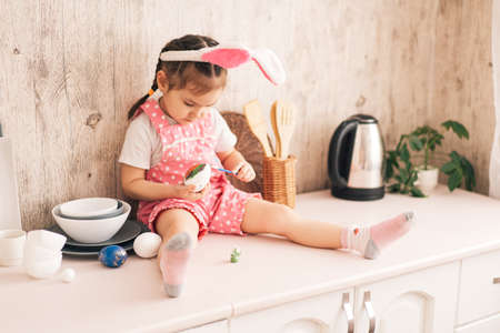 Little Child paints eggs with different colorsの写真素材