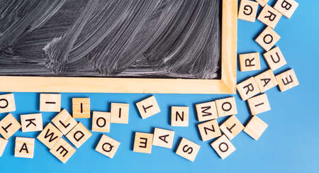 Chalk board with white stains next to Latin letters on blue backgroundの写真素材