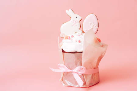 Gift easter cake with pink bow and cookies in the form of rabbit and eggsの写真素材