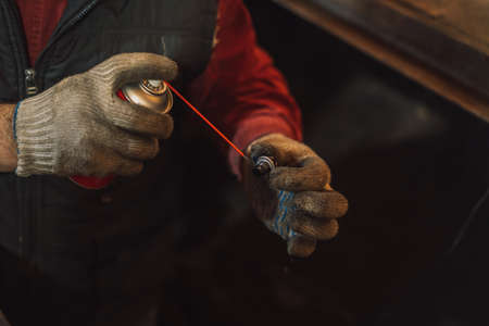 Man cleans the engine plug with solution from soot