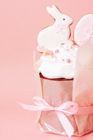Gift cake with cookies in the form of rabbit and eggs against pink background