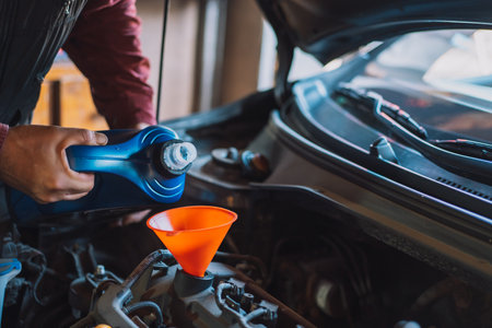 Mechanic pouring new oil into the engineの写真素材