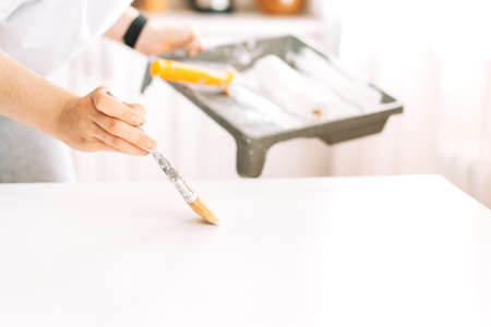 Painting wooden table white colour with brushの写真素材