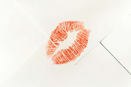 Red lipstick kiss mark on white envelopeの写真素材