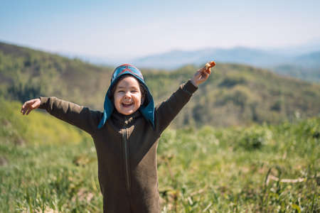 Girl dressed as pilot runs across field under the open skyの写真素材