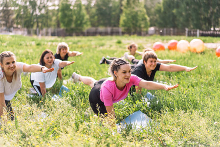 Group of women doing fitness on the grassの写真素材