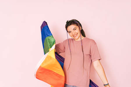 Girl with LGBT flag in front of a pink background