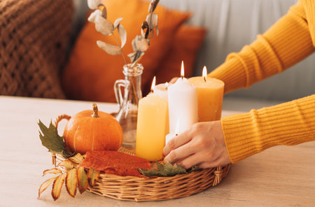 Autumn interior and festive mood with burning candles and pumpkinの写真素材