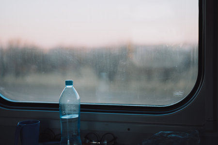 Bottle of water in front of the train compartment window