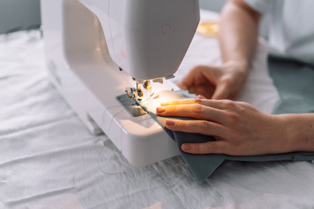 Lady stitching the edges of the fabric of a sewing machineの写真素材