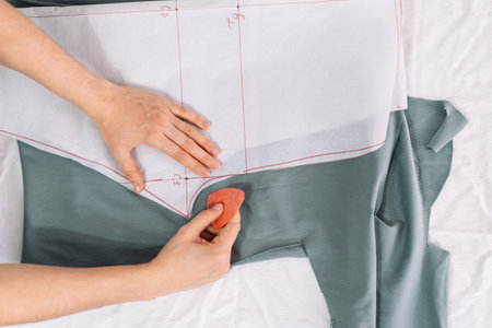 Lady draws patterns on the fabric with chalk