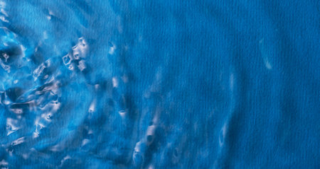 Waves propagate through the water on a blue backgroundの写真素材