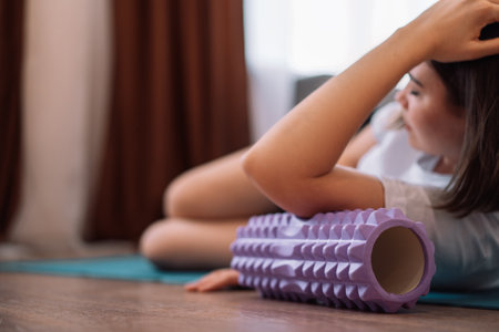 Lady gives herself a hand massage with a purple massage rollerの写真素材