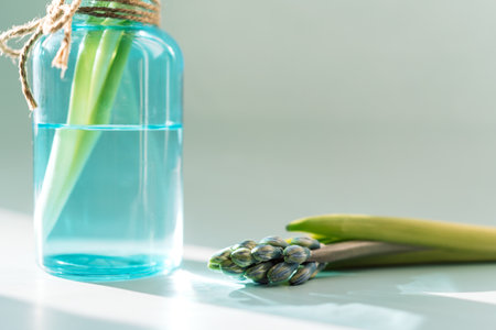 Blooming hyacinth in a blue water bottle under a sunbeam on a white backgroundの写真素材