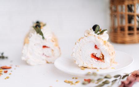 Meringue roll without sugar on a white plate cut into pieces