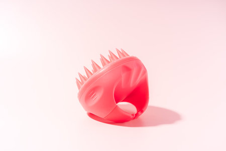 Pink colored scalp massager against pink backgroundの写真素材