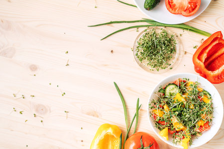 Vegetable salad with microgreens near ingredients on wooden tableの写真素材