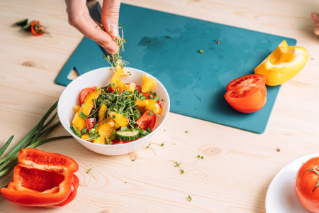Lady sprinkles vegetable salad with microgreensの写真素材